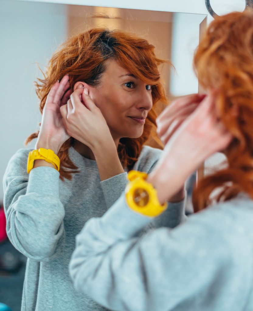 Woman with disability putting a hearing aid in her ear